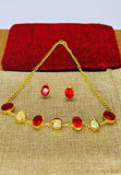Gold plated necklace and earring set featuring red glass stones and raw pearl. Handcrafted statement jewellery.
