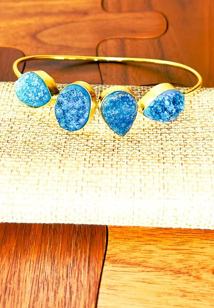 Gold plated adjustable bangle with multicolored druzy stones.