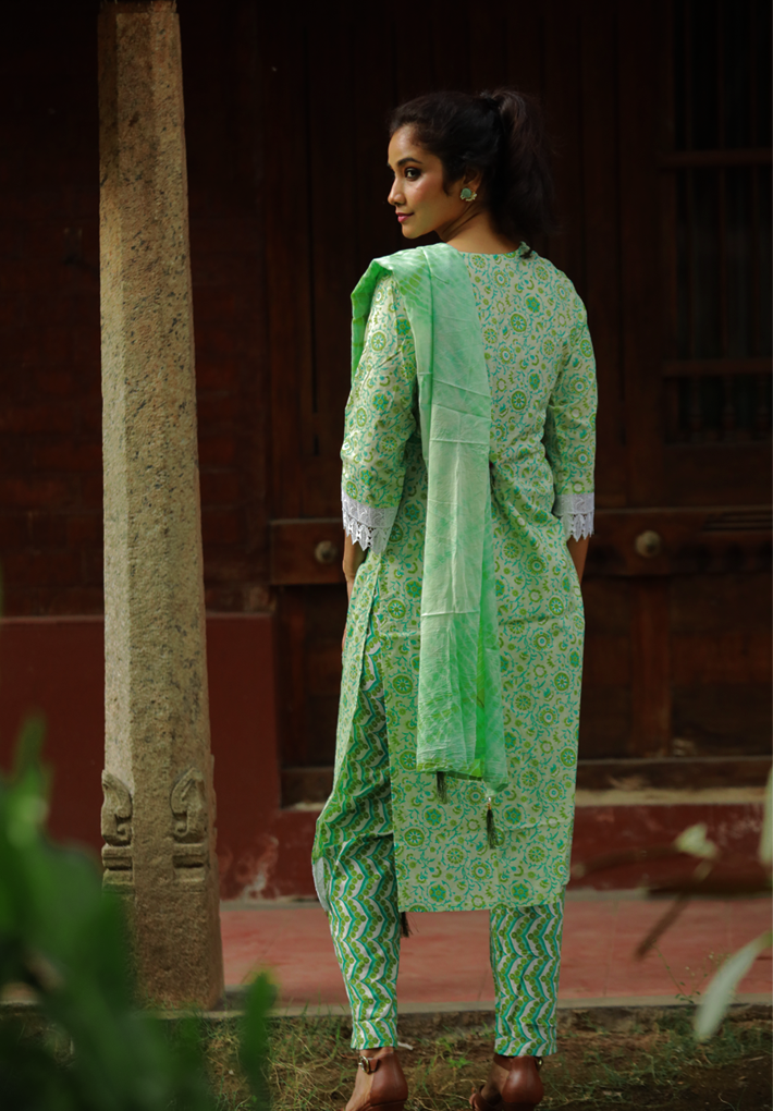 3 Piece Salwar - 100% Cotton green  salwar with floral prints, mirror work and elegant crochet work .Green printed dupatta and matching pants with ikkat prints. Round neck. 3/4th sleeve. Straight hemline