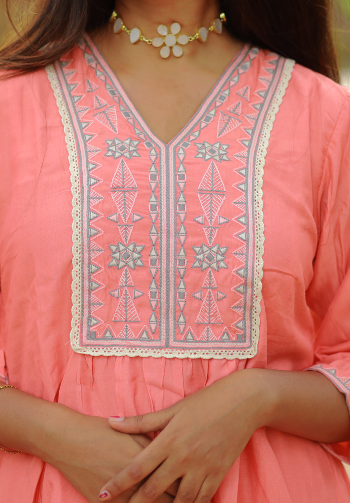 Tunic - Patterned peach rayon tunic with embroidery, crochet works and flared sleeves. 3/4th Sleeve with matching embroidery. Round neck. Flared hemline.
