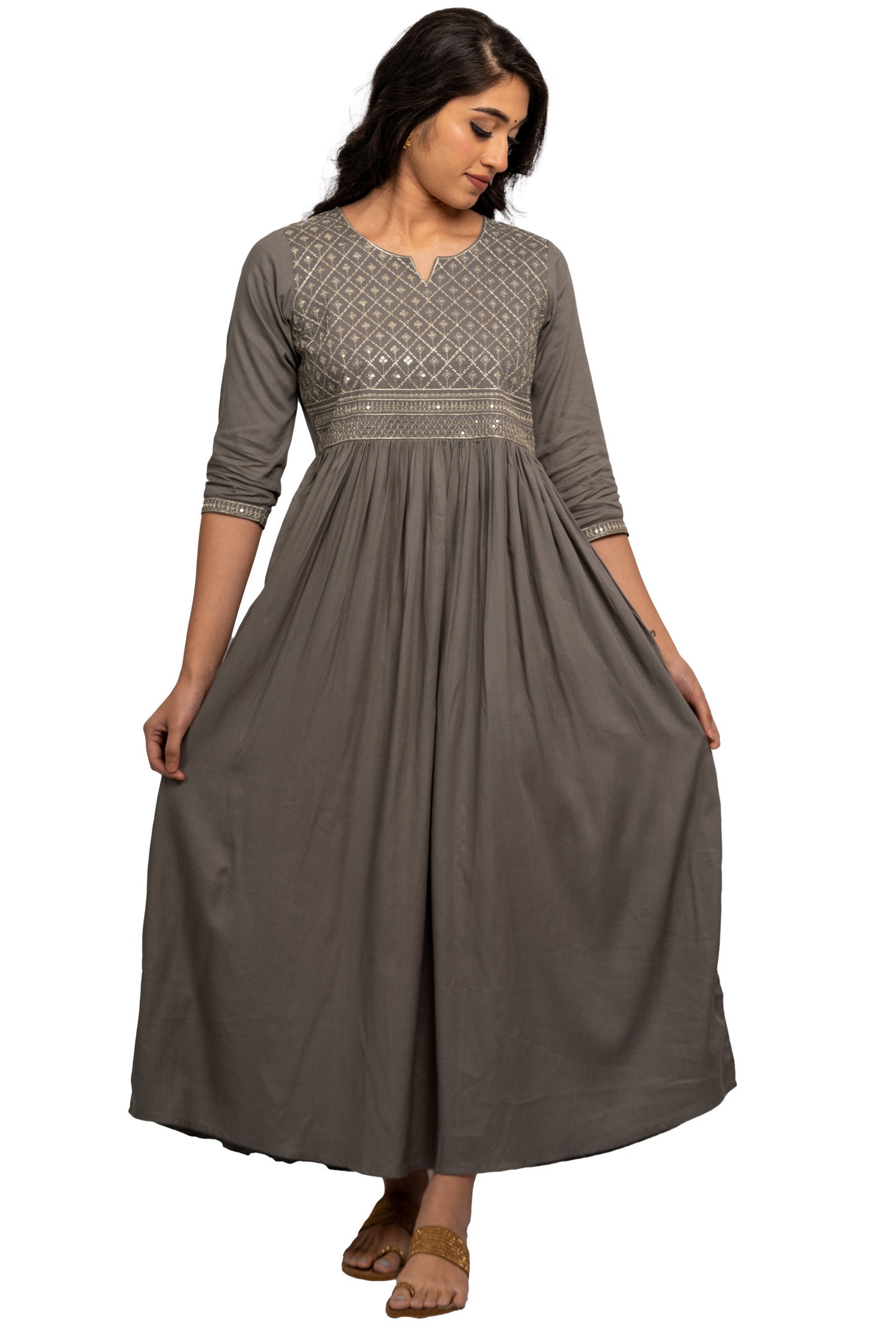 Full Gown - Grey full gown with rich silver embroidery in the front and gather detail. 3/4th Sleeve with matching embroidery at the tip. Round neck with V cut. Flared hemline deriving from the gather detail. Rayon material.